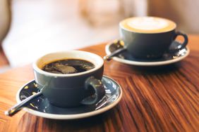 A hot latte and an Americano in coffee mugs