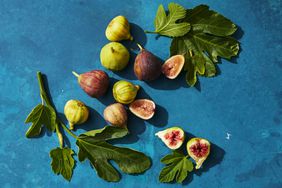 figs and fig leaves on blue background