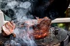 Meat being smoked in a grill.