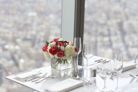 Flowers and empty wine glasses on a table at One World Observatory.