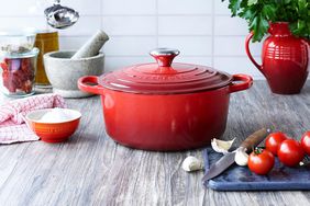 The Le Creuset Enameled Cast Iron Signature Round Dutch Oven on a counter with food prep items